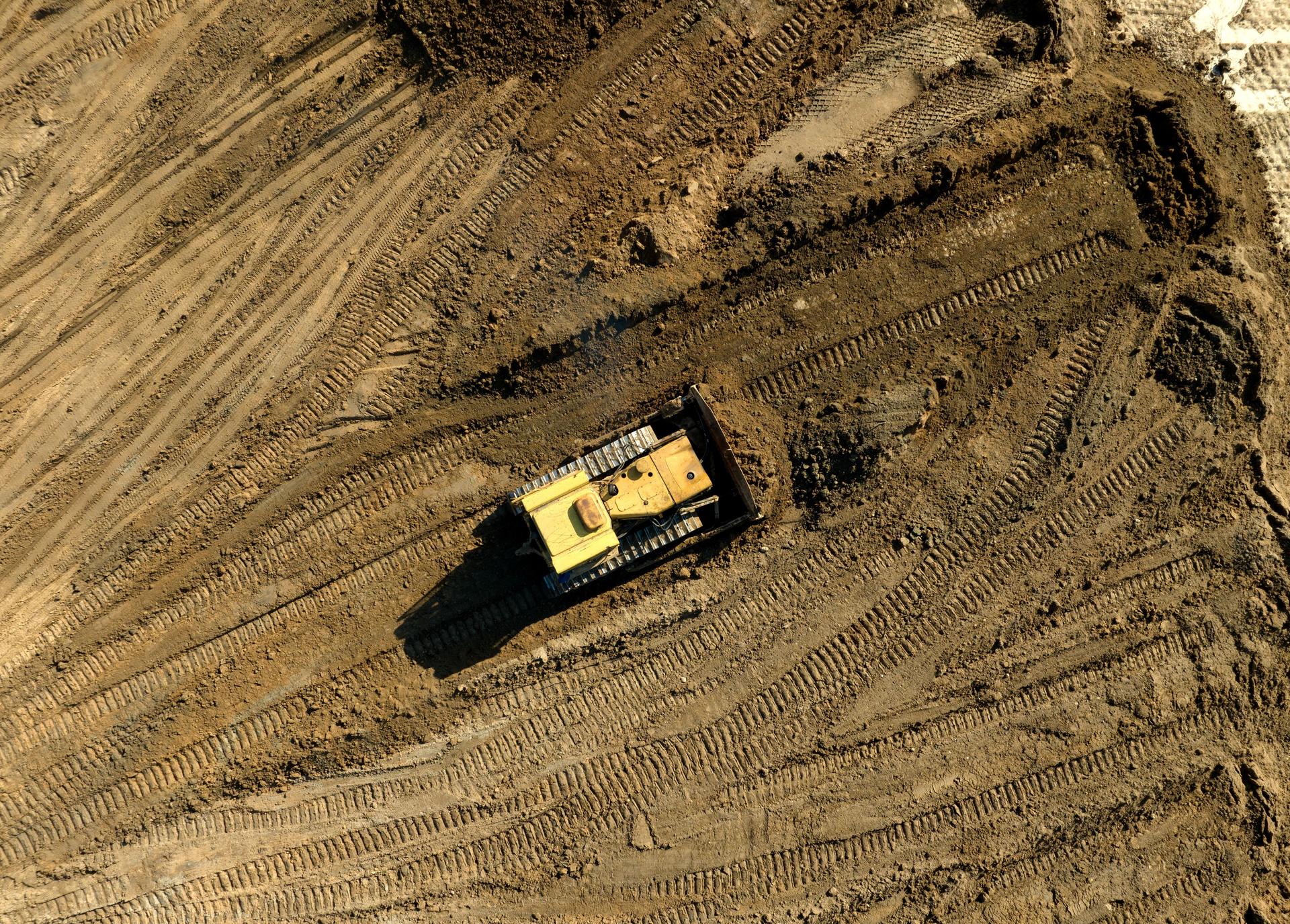 Bulldozer at mine reclamation once mining sand is completed. Land clearing, grading, pool excavation, utility trenching.